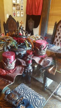 a dining room table covered in pink candles and other decorative items on top of it