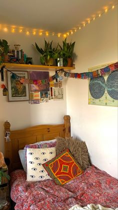 a bedroom with a bed and some plants on the wall above it is decorated with string lights