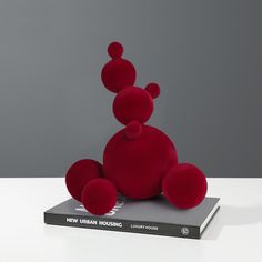 a red stuffed animal sitting on top of a book