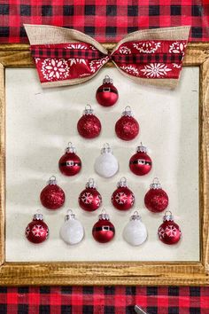 a christmas tree made out of red and white baubles in a wooden frame