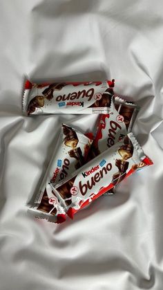 three bars of chocolate sitting on top of a white sheet