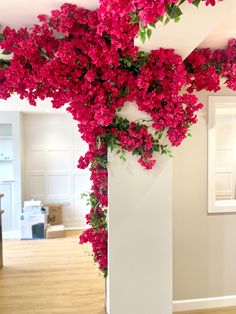 a tall white vase filled with pink flowers