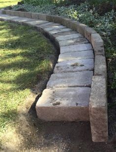 a stone path in the middle of some grass