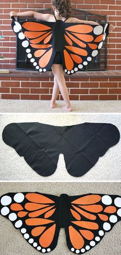 a girl is standing in front of a brick wall with an orange and black butterfly wings