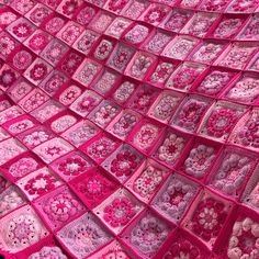 a pink crocheted blanket with flowers on it