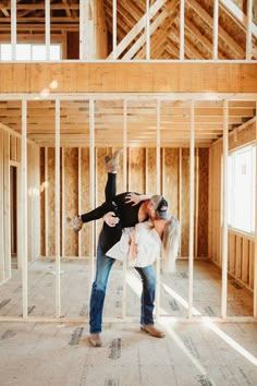 a man and woman standing in an unfinished room with their arms around each other as they hug