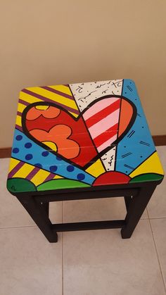 a small wooden stool with a heart painted on it