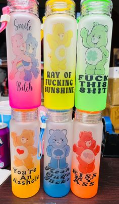 four plastic water bottles with different designs on them sitting on a table in front of other items