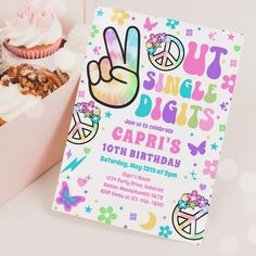 a pink box filled with cupcakes and cake next to a peace sign birthday card