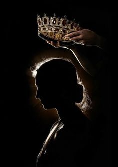 the silhouette of a person with a crown on their head, against a dark background