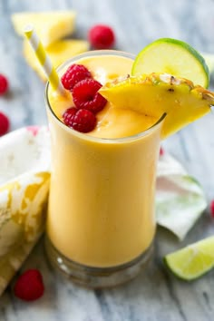 a smoothie with raspberries and kiwi on the side