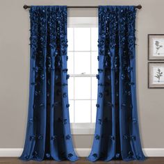 blue curtains with flowers on them in front of a white wall and wooden flooring