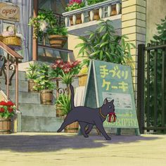 a black cat is standing in front of a building with flowers and plants on it