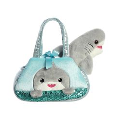 a stuffed shark is sitting next to a purse with a shark on it's side