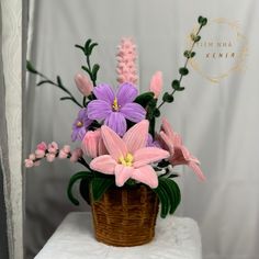 a basket filled with pink and purple flowers