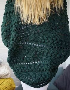 a woman wearing a green crocheted sweater