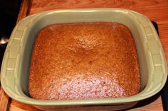 a square cake in a green dish on a wooden table