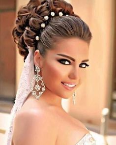 a woman in a wedding dress with pearls on her hair