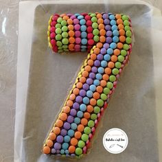 a cake shaped like the number seven is decorated with colorful candies and icing