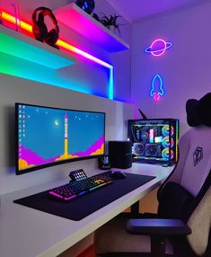 a computer desk with two monitors and a keyboard in front of the monitor is lit up by neon lights