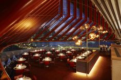 the inside of a restaurant with red chairs and tables in front of a large window