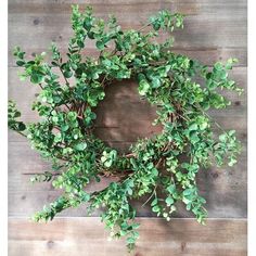 a green wreath on top of a wooden table