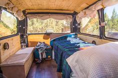 the interior of an old camper van with two beds and suitcases in it