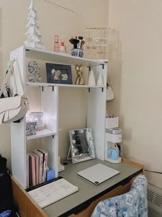 a desk with a laptop and some books on it in front of a christmas tree