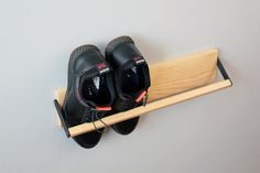 two pairs of black shoes sitting on top of a wooden shoe rack