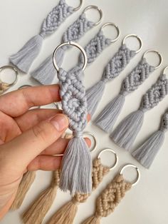 a hand holding a keychain with tassels in different colors and sizes