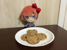 a paper plate with chocolate chip cookies and a doll