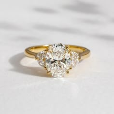 a three stone diamond ring on a white surface