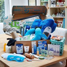 the contents of a blue teddy bear sitting on top of a wooden table in front of a window