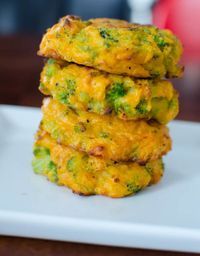 broccoli fritters stacked on top of each other on a white plate