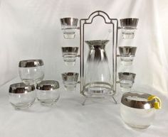 an assortment of glass and metal items on a white background with a lemon slice in the foreground