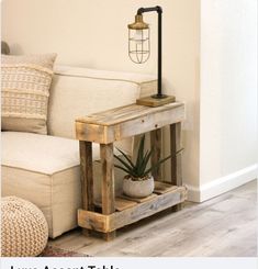 a living room with a couch, table and potted plant on the end shelf