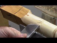 a person holding a knife in front of a piece of wood