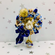 a blue and gold christmas wreath on top of a table