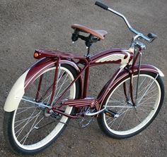 a red and white bicycle is parked on the pavement