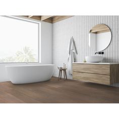 a white bath tub sitting next to a wooden dresser and mirror in a bathroom under a large window