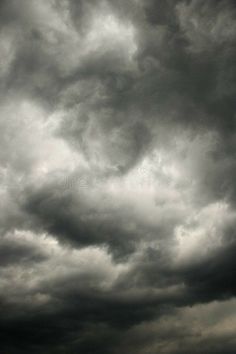 an airplane flying in the cloudy sky with dark clouds above it royalty images and stock photography