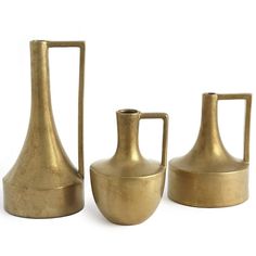 three brass colored vases sitting next to each other