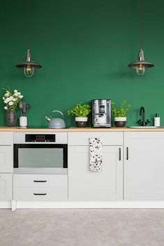 a kitchen with green walls and white cabinets