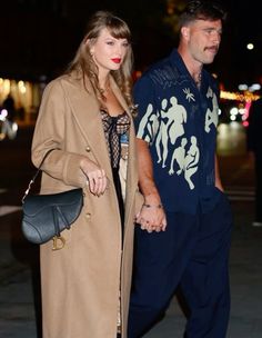 a man and woman walking down the street holding hands