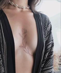 a close up of a woman's breast with a flower tattoo on her chest