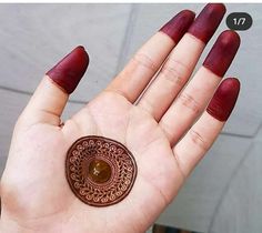 a woman's hand holding a brown and red sticker on her left palm