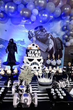 a star wars themed birthday party with balloons and desserts on the table in front of it