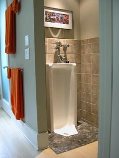 a white urinal sitting in the middle of a bathroom