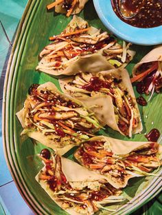 some food is laying out on a green platter with sauces and condiments