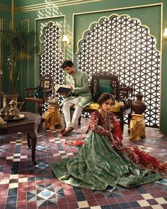 two people sitting on chairs in an ornate room